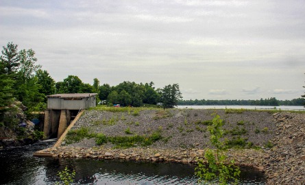 A large dam in the forefront with a lake in the background